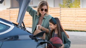 Frau und Mädchen vor Elektroauto